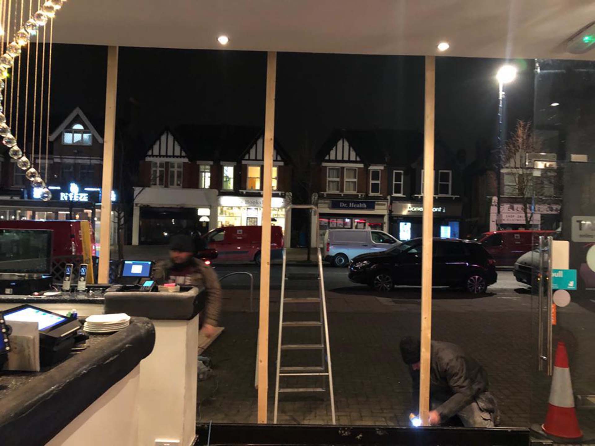 EBU South workers repairing cafe display window.